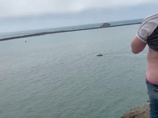 Zoey droçit etmek in jemagat öňünde high on a rock in the harbor